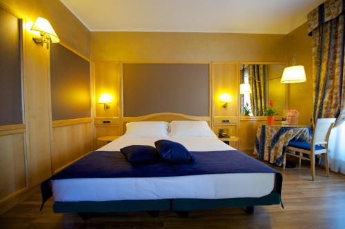 a bedroom with a large bed with two pillows on it at Best Western Hotel Luxor in Turin