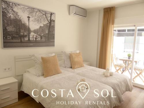 sypialnia z łóżkiem z plakatem na ścianie w obiekcie LA CARIHUELA TORREMOLINOS- STUDIO 1- COSTA SOL HOLIDAY RENTALS w mieście Torremolinos