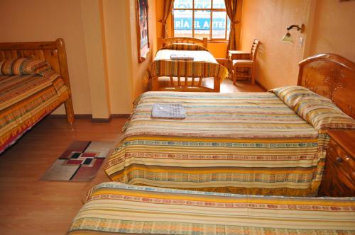 a room with two beds and a table at Hotel Santafe Inn in Otavalo