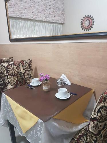 a table with two cups and saucers on it at San Carlos Hotel in Buenos Aires