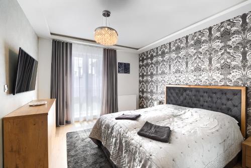 1 dormitorio con 1 cama con pared estampada en blanco y negro en Toress Apartamenty Deptak, en Szczecin