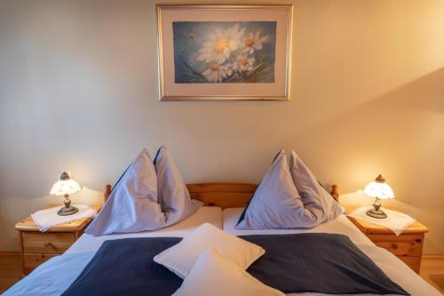 a bedroom with two beds with pillows and a painting at Urlaub am Lacknerhof - Familie Klocker in Liebenfels