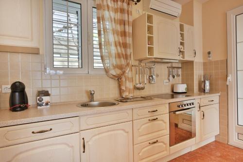 a kitchen with white cabinets and a sink at Royal Holiday Apartments Sveti Stefan in Sveti Stefan