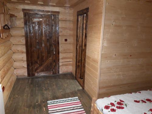 a room with a bed in a wooden cabin at Маєток горгани in Synevyrsʼka Polyana