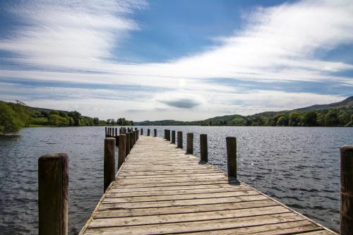 a wooden dock in the middle of a lake at Church View Apartment in Coniston