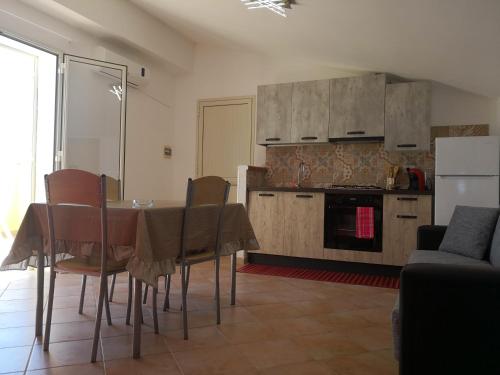a kitchen with a table and chairs in a room at Holiday Beach Lumia in Sciacca