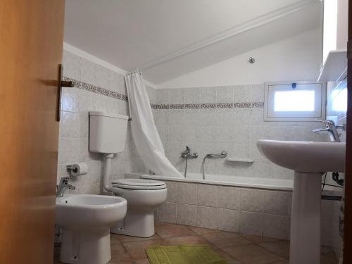 łazienka z toaletą, umywalką i wanną w obiekcie Holiday Beach Lumia w mieście Sciacca