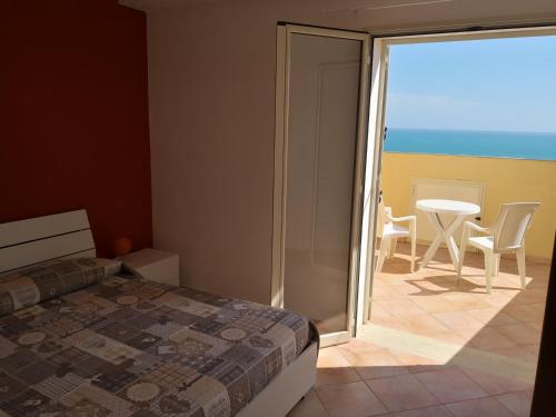 sypialnia z łóżkiem i widokiem na ocean w obiekcie Holiday Beach Lumia w mieście Sciacca