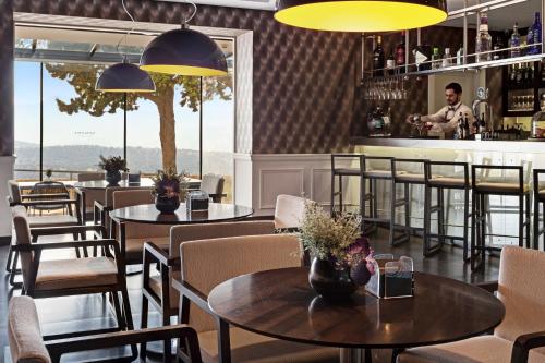 a restaurant with tables and chairs and a bar at Catalonia Reina Victoria in Ronda