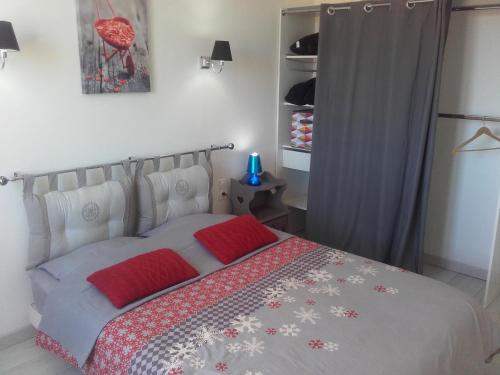 ペルピニャンにあるAppartement del Solのベッドルーム1室(赤い枕のベッド1台付)