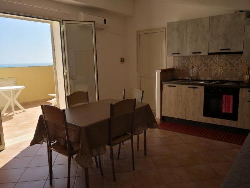 a kitchen and dining room with a table and chairs at Holiday Beach Lumia in Sciacca