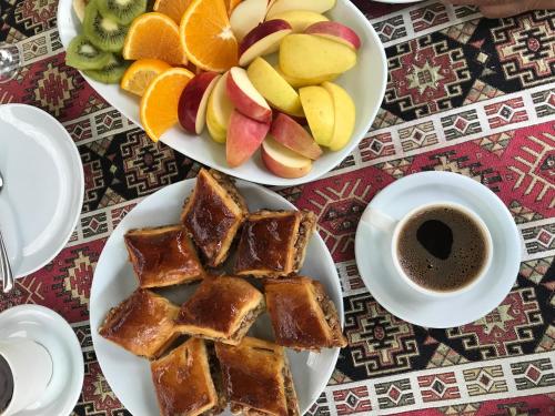 two plates of food with fruit and a cup of coffee at Christy Hotel in Goris