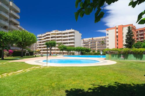 a swimming pool in a park with buildings in the background at UHC Jerez Cordoba Sevilla Apartments in Salou