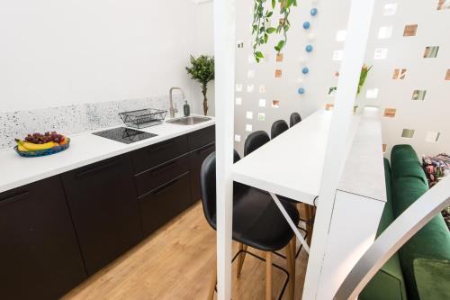 a kitchen with a white counter and black cabinets at Bliss Apartments in Poznań