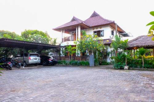 a house with a car parked in front of it at Friends Beach Hotel in Kuta Lombok