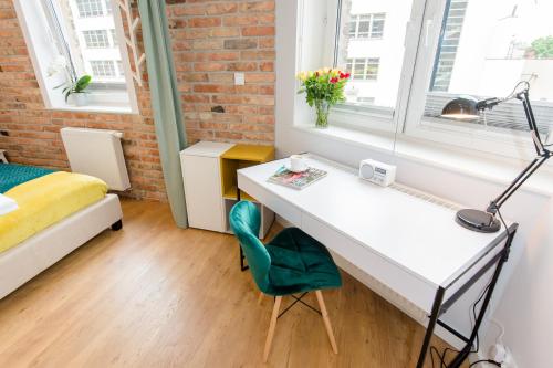 a bedroom with a desk and a bed and a window at Bliss Apartments in Poznań
