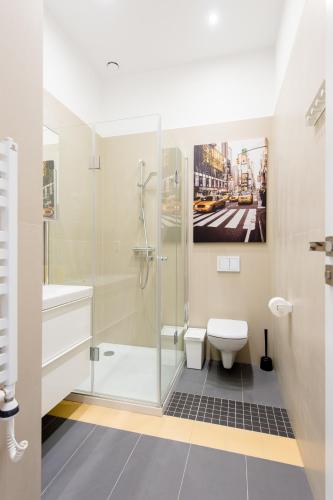 a bathroom with a shower and a toilet and a painting at Bliss Apartments in Poznań