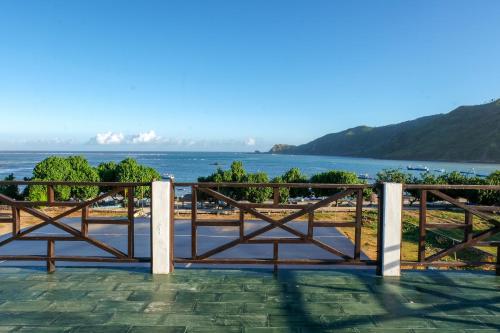 a wooden fence with a view of the water at Friends Beach Hotel in Kuta Lombok