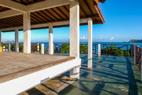 a porch of a house with a view of the ocean at Friends Beach Hotel in Kuta Lombok