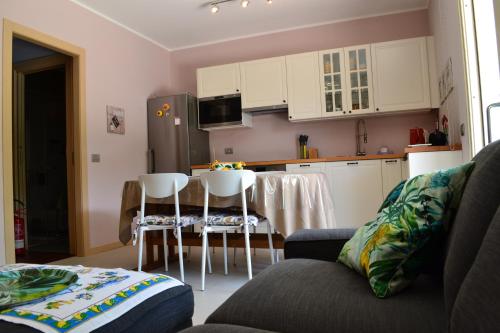 eine Küche mit weißen Schränken und einem Tisch und Stühlen in der Unterkunft La Bella Italia in Desenzano del Garda