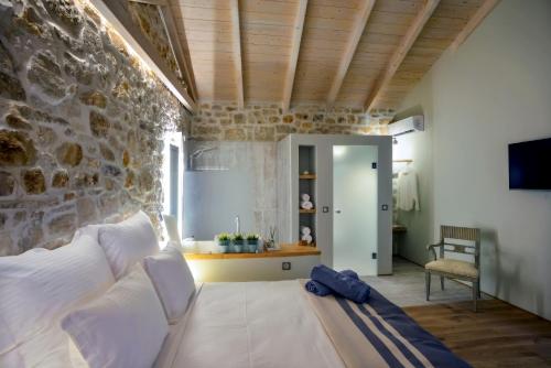 a living room with a couch and a stone wall at Paxos Fairytales Lovenest 2 in Gaios