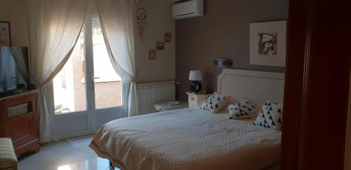 une chambre avec un lit et une grande fenêtre dans l'établissement Villa climatisée piscine privée classée 4 étoiles, à Laroque-des-Albères
