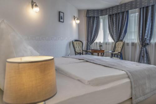 a bedroom with a bed and a table and chairs at Erla Villa Boutique Hotel in Eger