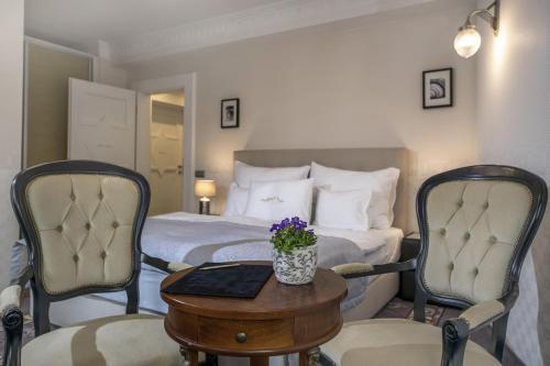 a hotel room with a bed and a table and chairs at Erla Villa Boutique Hotel in Eger
