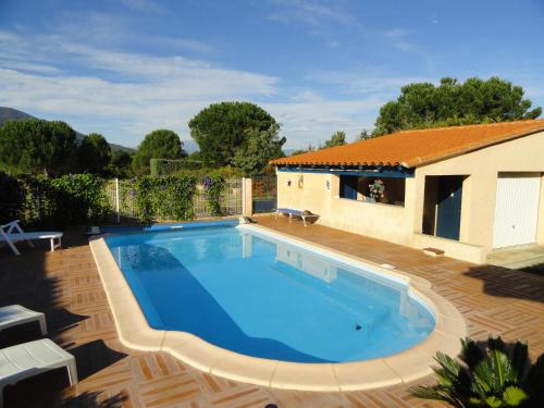 une piscine devant une maison dans l'établissement Villa climatisée piscine privée classée 4 étoiles, à Laroque-des-Albères