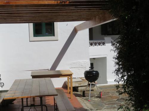 a grill and picnic table in front of a building at A Quinta da Colina ( Casinha ) in Castanheira de Pêra