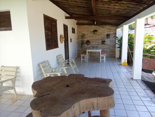 a room with a table and chairs on a patio at Casa Porto de Pedras_Patacho_Milagres in Pôrto de Pedras