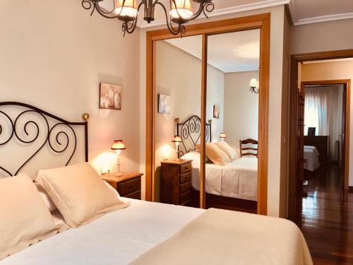 une chambre avec deux lits et un grand miroir dans l'établissement Llanes mar y montaña, à Llanes