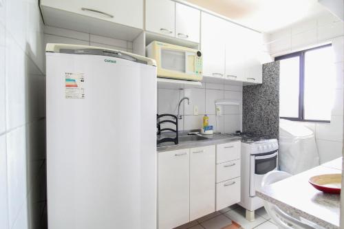 Apartamento c/ Piscina e Garagem | CDC 3120/602 في موسورو: مطبخ مع دواليب بيضاء وثلاجة
