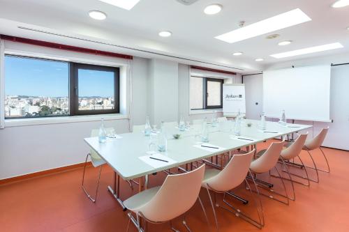 a conference room with a long table and chairs at Radisson Blu Hotel Lisbon in Lisbon