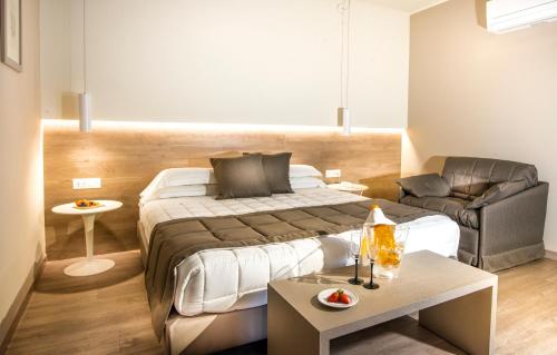 a hotel room with a bed and a couch at Guesia Village Hotel e Spa in Foligno