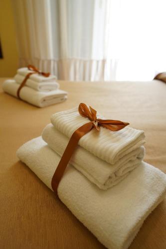 duas toalhas com uma fita em cima de uma cama em B&B Conte Cavour em Nápoles