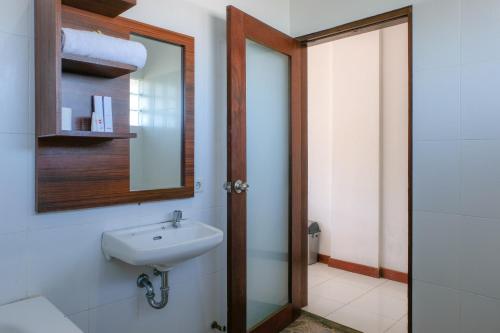 a bathroom with a sink and a mirror at Friends Beach Hotel in Kuta Lombok