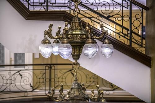 a chandelier hanging from a staircase in a building at Erla Villa Boutique Hotel in Eger