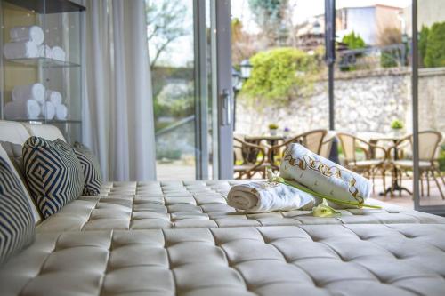 a bed with pillows on it in a living room at Erla Villa Boutique Hotel in Eger