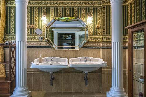 a bathroom with two sinks and a mirror at Erla Villa Boutique Hotel in Eger