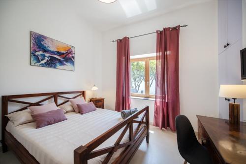 Schlafzimmer mit einem Bett, einem Schreibtisch und einem Fenster in der Unterkunft B&B PROCHYTEA in Procida