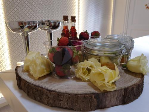 a wooden cutting board with jars of fruit and wine glasses at Christian's Suites & Spa in Fasano
