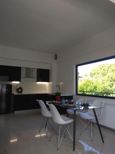a kitchen and dining room with a table and chairs at DREAM & HARMONY in Artemida