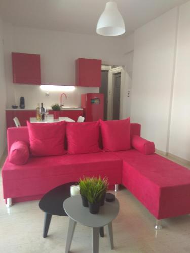 a living room with a red couch and a table at DREAM & HARMONY in Artemida
