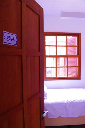 a door to a bedroom with a bed and a window at Green 53 Boutique Hotel in Ilhéus