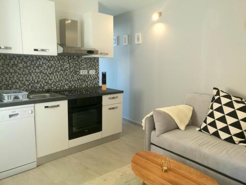 ein Wohnzimmer mit Couch und Küche in der Unterkunft Apartment Seashell in Šišan