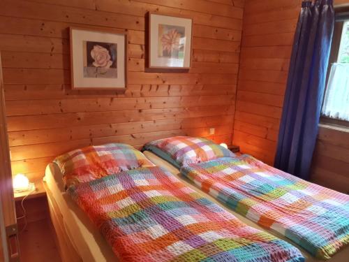 two beds in a room with wooden walls at Milena-Hütte in Hohentauern