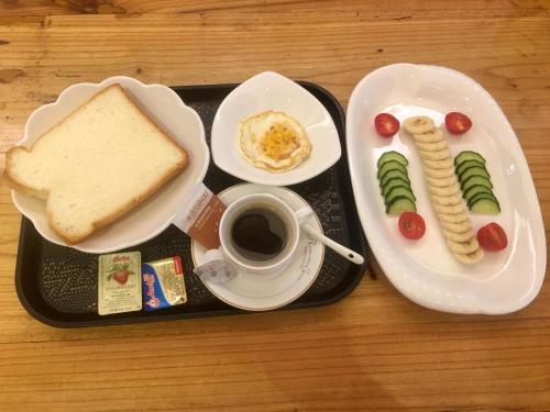 a tray of food with a sandwich and a cup of coffee at Zhangjiajie National Park Yuelu Homestay in Zhangjiajie