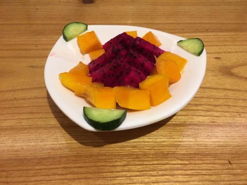 a plate of fruit on a wooden table at Zhangjiajie National Park Yuelu Homestay in Zhangjiajie