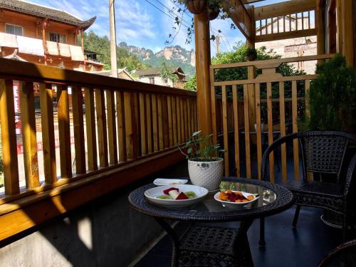 a table with two bowls of fruit on a balcony at Zhangjiajie National Park Yuelu Homestay in Zhangjiajie